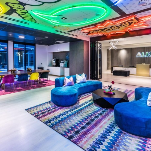 Settle into comfort at Aliso Apartments a room with blue chairs and a colorful ceiling