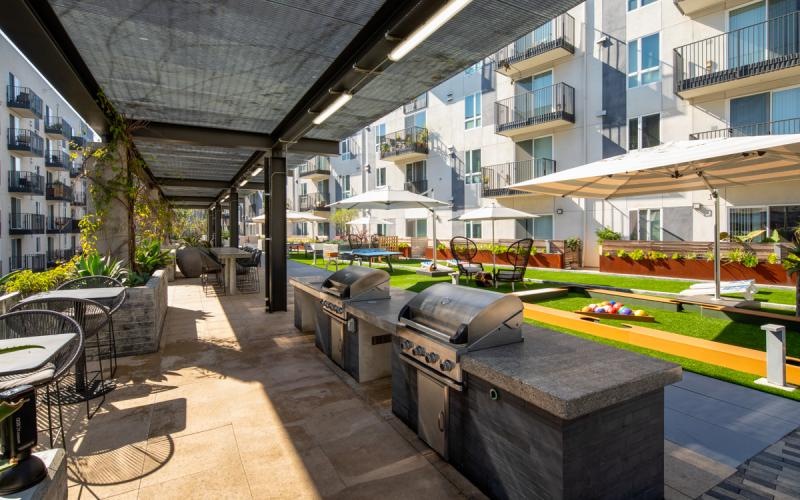 a courtyard with tables and chairs and a building with a pool